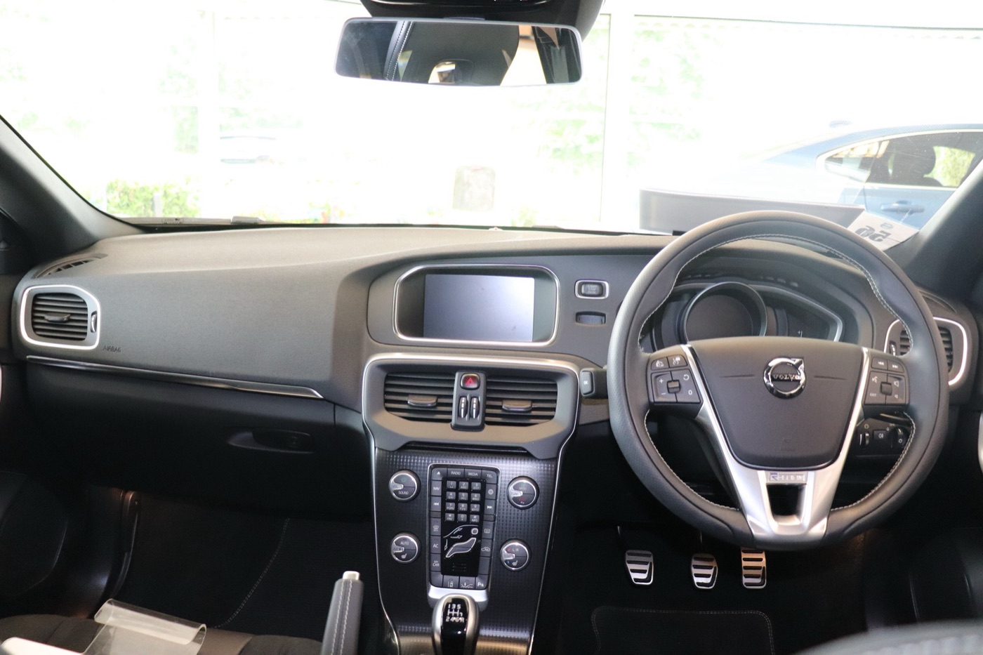 Dashboard of a right-hand-drive Volvo V40 R-Design with a floating centre console, sat-nav screen and three-spoke sports steering wheel