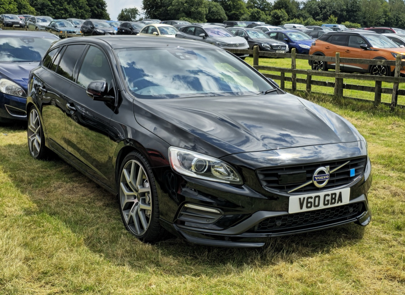 Black 2015 Volvo V60 Polestar estate from the front three-quarter, parked on grass in a show car park