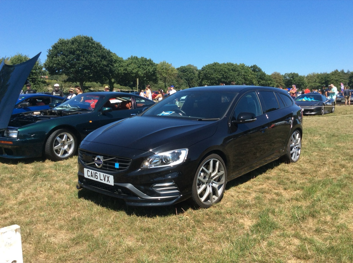 Black Volvo V60 Polestar estate with 20-inch Polestar wheels parked on grass at a car show