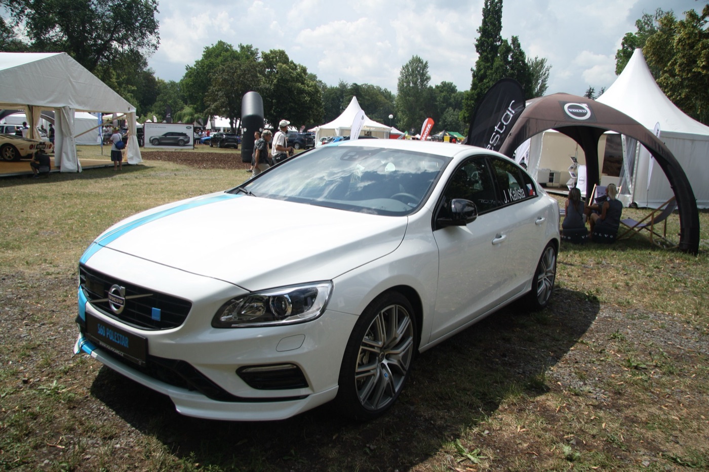 White Volvo S60 Polestar saloon with a pale blue stripe over the bonnet, parked on grass at an outdoor show