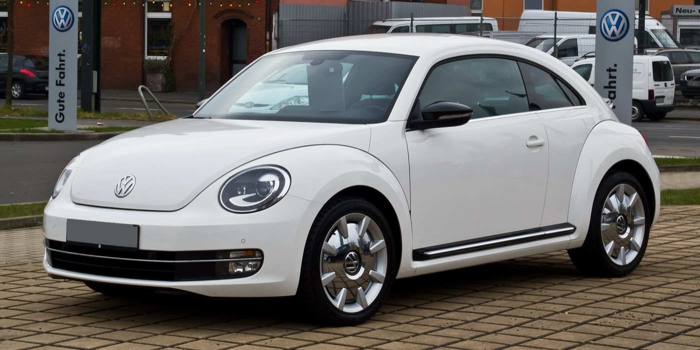 White Volkswagen Beetle A5 1.4 TSI Sport with chrome wheel trims outside a Volkswagen dealer