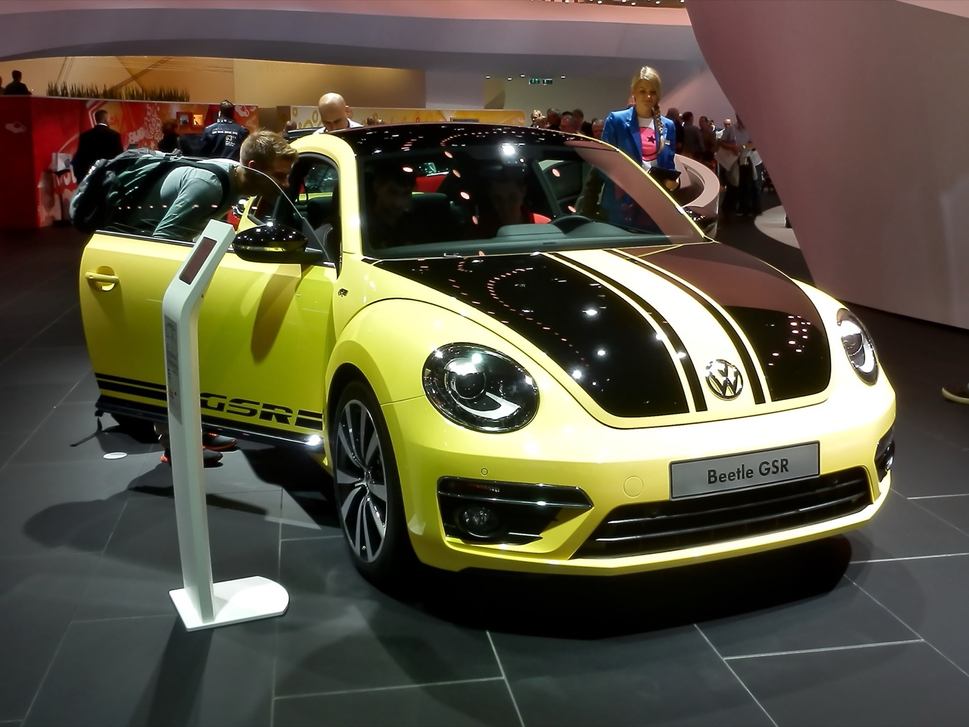 Yellow Volkswagen Beetle GSR with black bonnet stripes and GSR lettering on the sill at a motor show