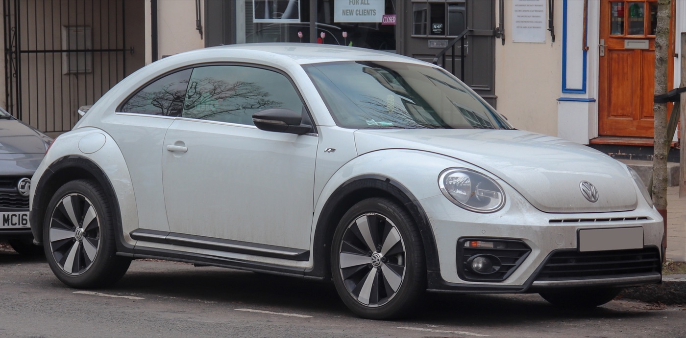 White Volkswagen Beetle R-Line with black wheel-arch trims and two-tone alloy wheels parked on a street