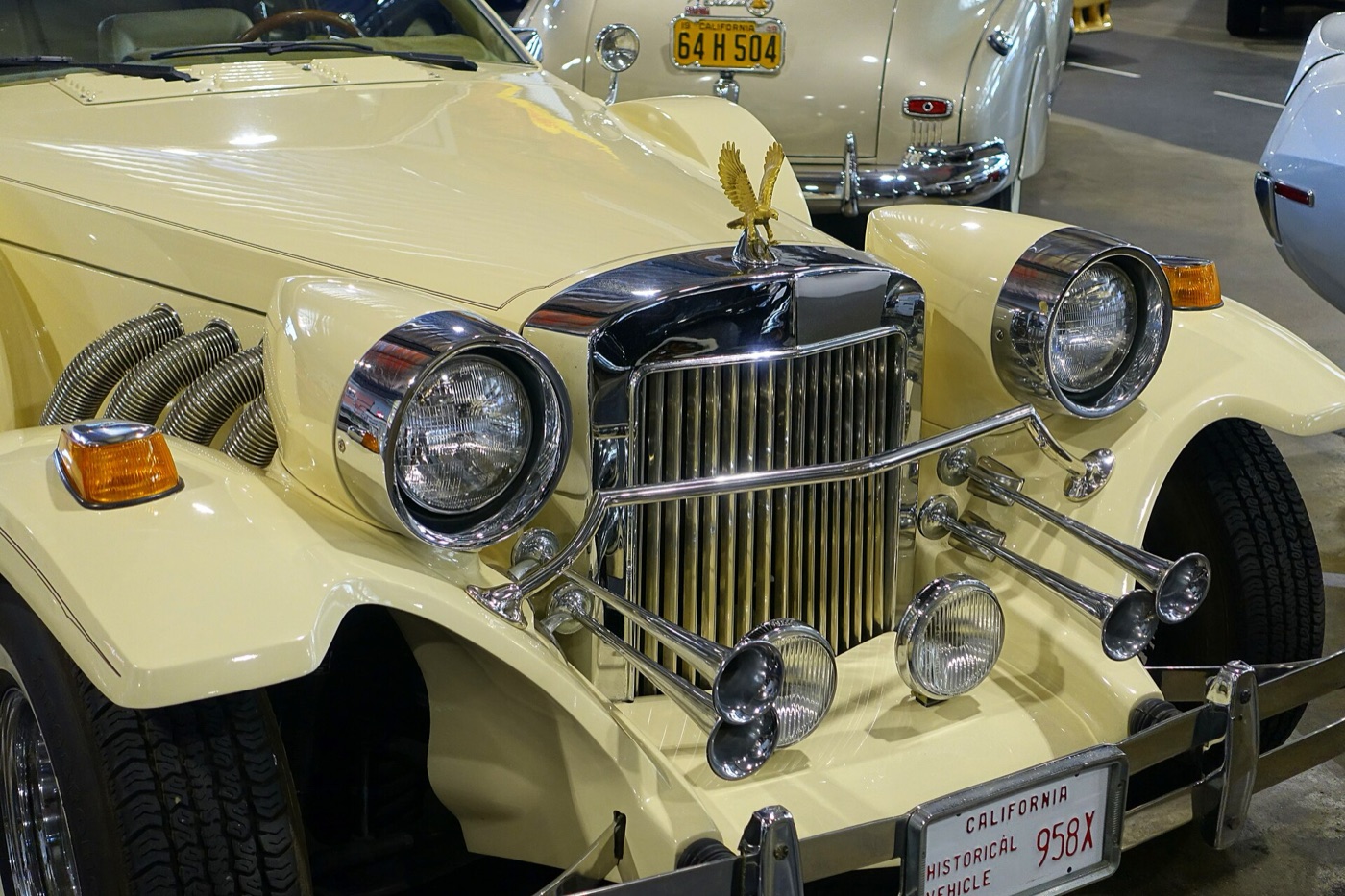 Cream Zimmer Golden Spirit nose with a chrome upright grille, a gold eagle mascot, large chrome headlamps, four chrome trumpet horns and flexible chrome exhaust pipes